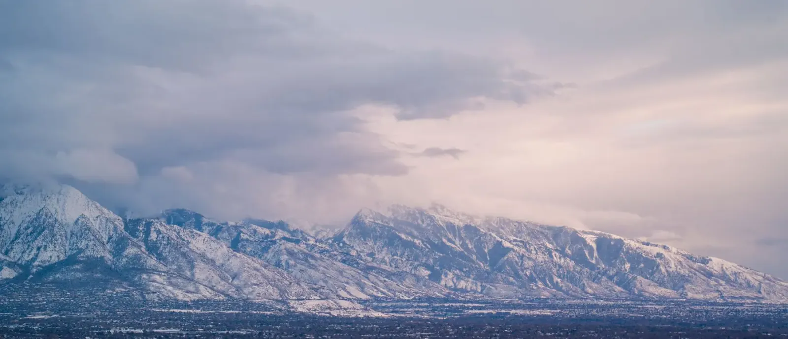 Snow-capped Wasatch mountains at sunset above the valley